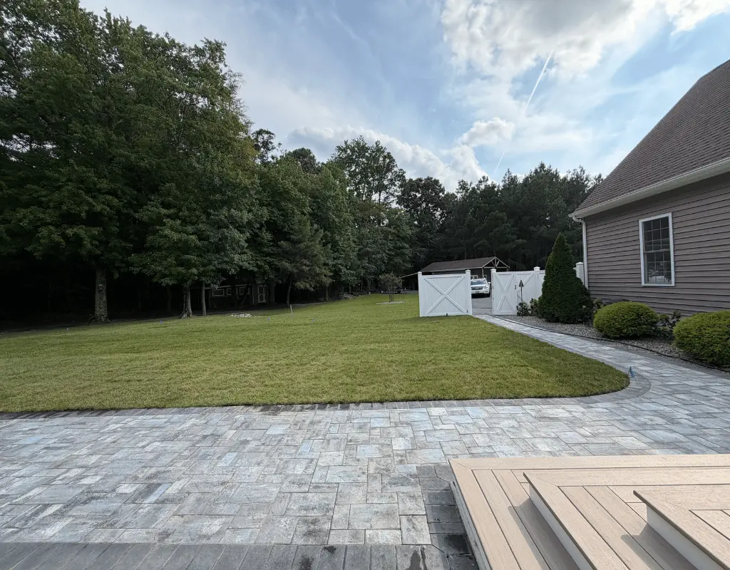 Freshly cut lawn beside a stone patio and white gate on a Delmarva Peninsula property